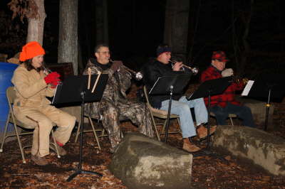 A band plaing trumpets with music stands outside at the Park